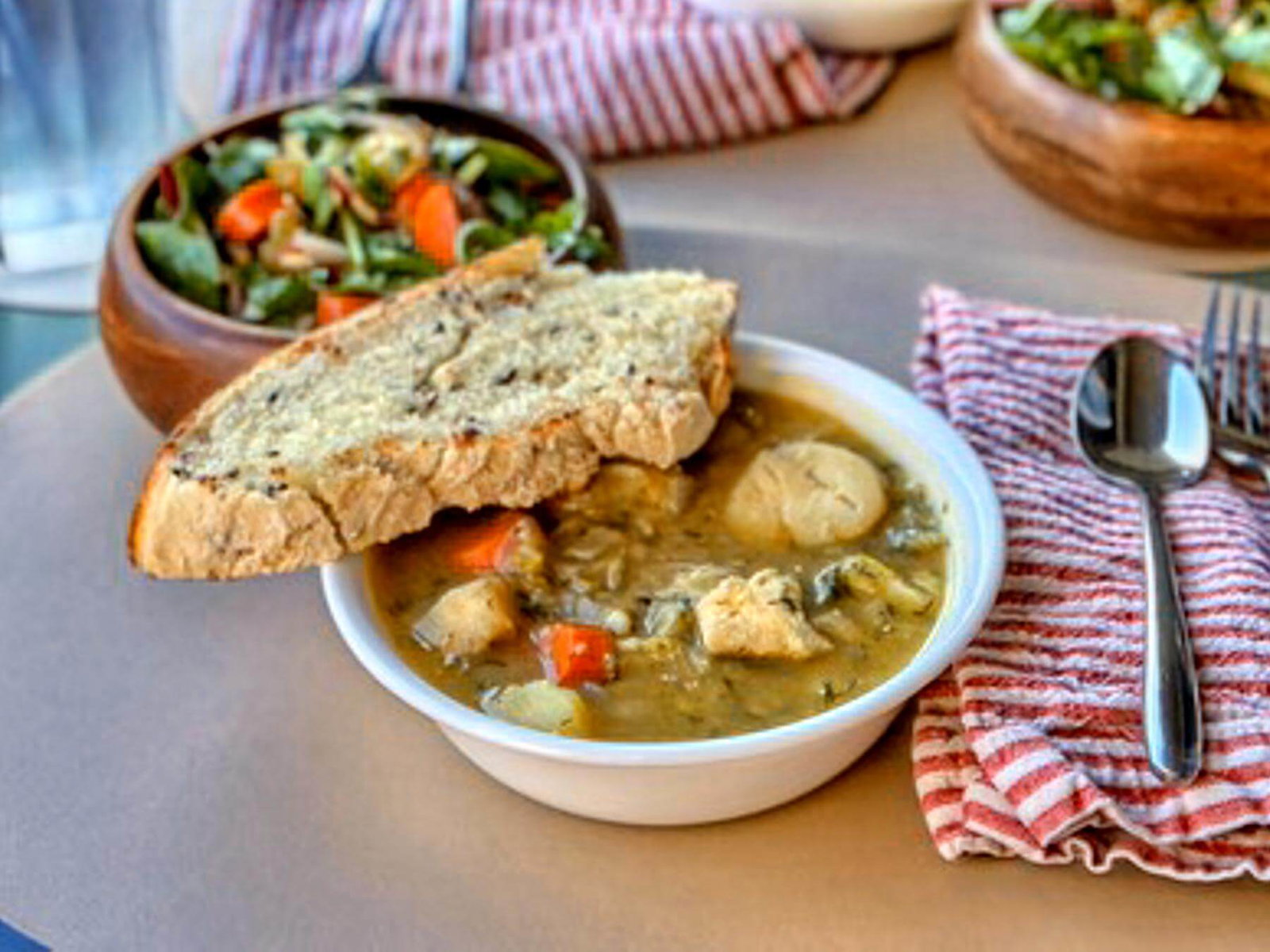 Fiskesuppe in white bowl on table with bread