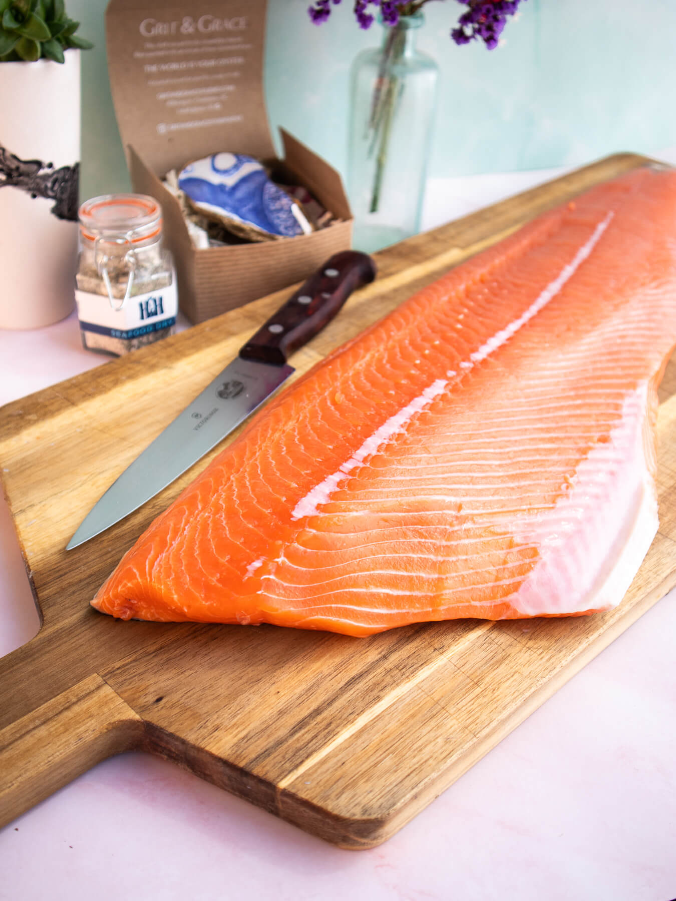 Whole King Salmon fillet on wooden cutting board with chef's knife