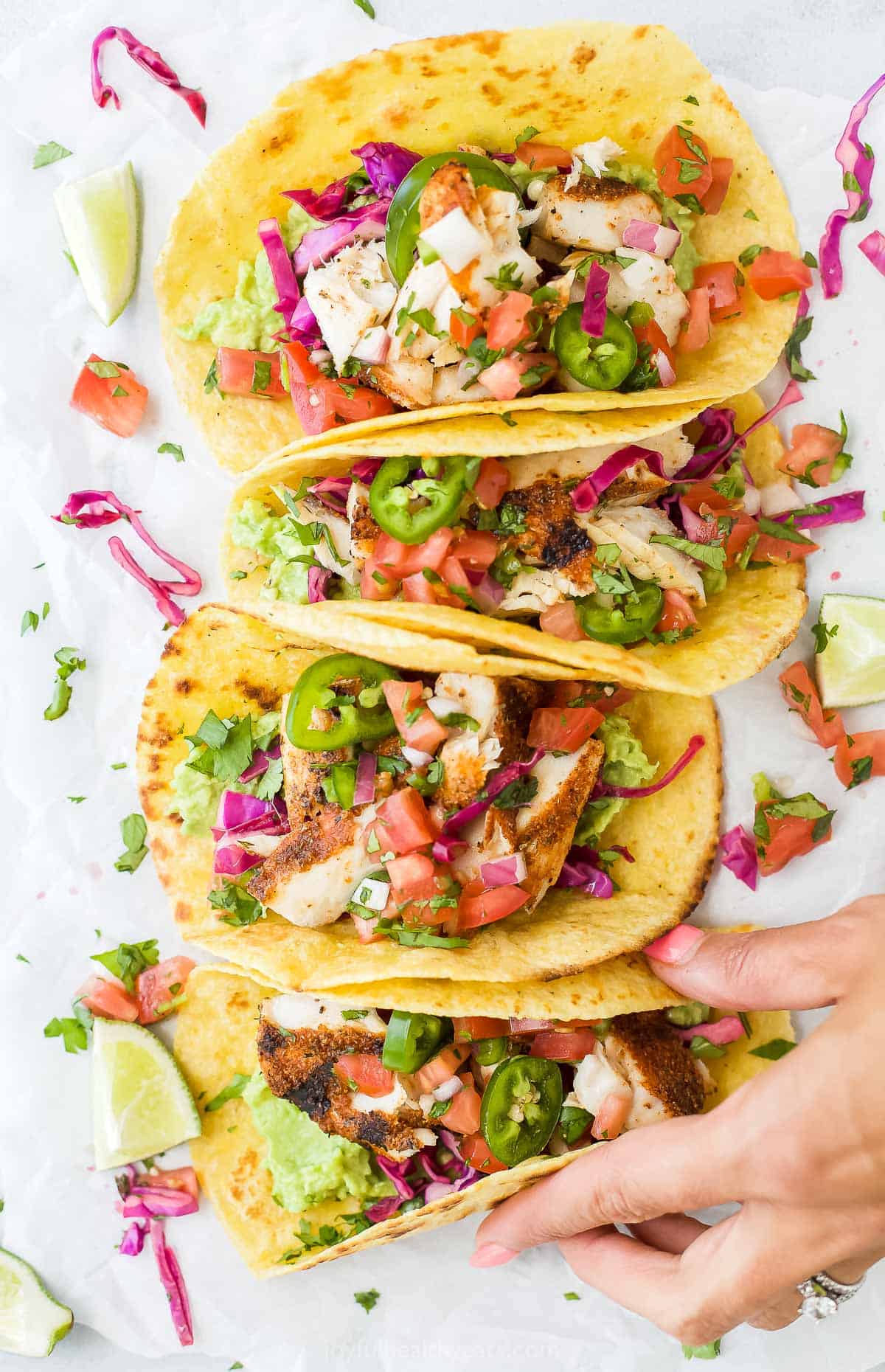 Flaky tender grilled fish seasoned with a smoky spice rub and topped with mashed avocado, smoky chipotle lime crema, pico de Gallo and cabbage slaw. These Mahi Mahi Tacos are a guaranteed crowd-pleaser and come together in just 30 minutes! #tacotuesday #fishtacos #grilledfish #tacorecipes #dinnerideas #easydinners