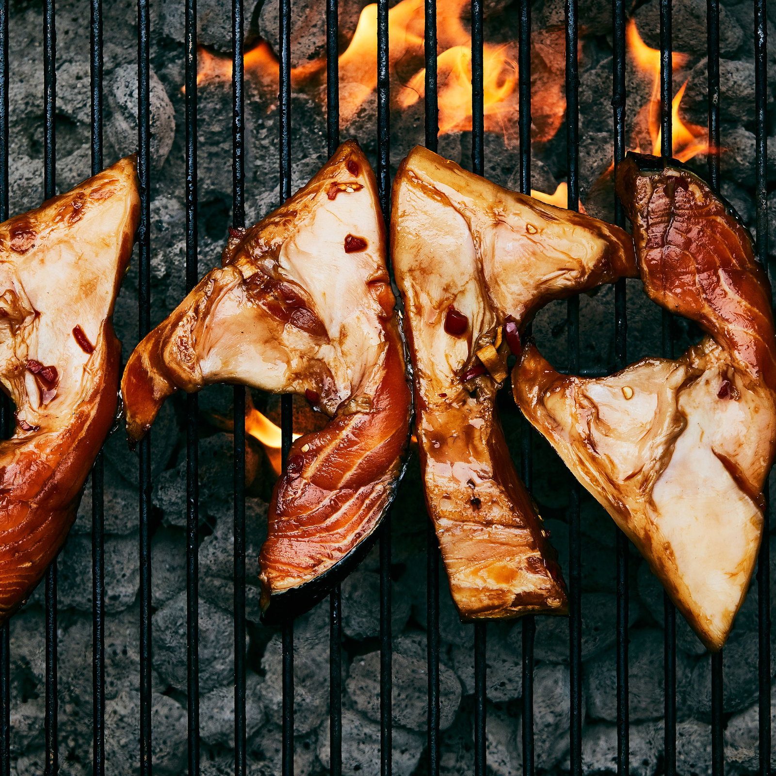 Salmon Collars on grill with flame showing underneath