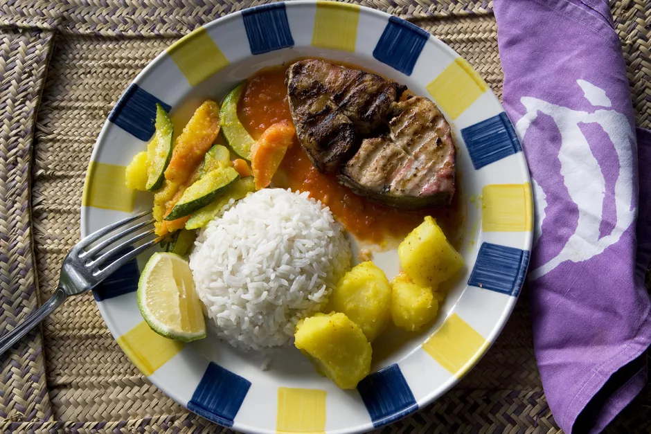 Grilled Shark Steak on yellow and blue plate with rice, lime, and potatoes