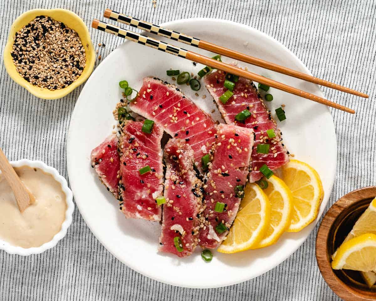 Ahi Tuna is coated in black and white sesame seeds and quickly seared in butter. Served on a bed of lettuce with a creamy sesame sauce, this dish is a win-win!